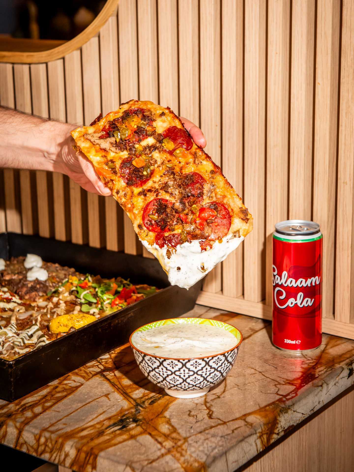 Toronto pizza | Dunking a slice of Levant Pizza into a dip