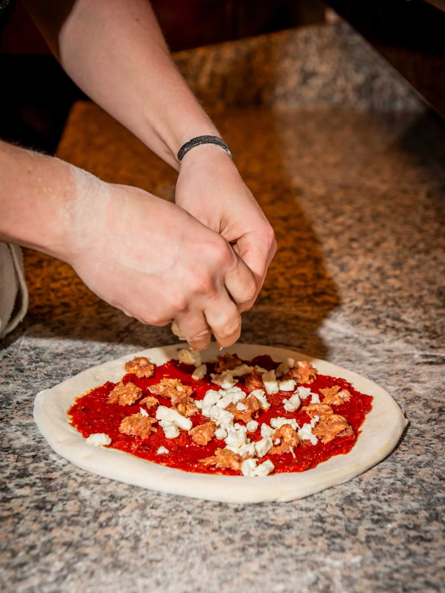 Toronto pizza | Adding the toppings to a pizza at Pizza e Pazzi