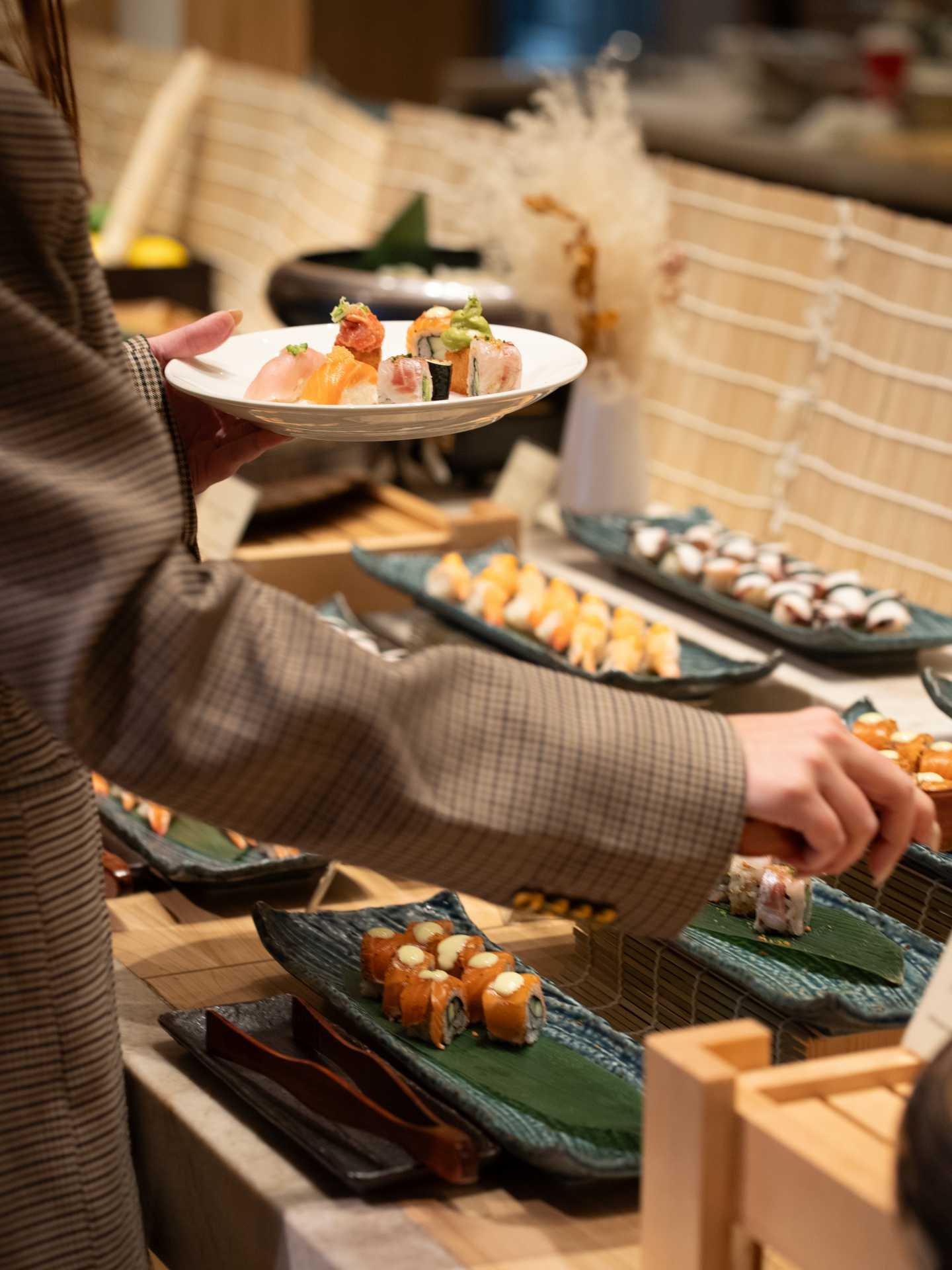Someone fills their plate at Nobu's buffet brunch