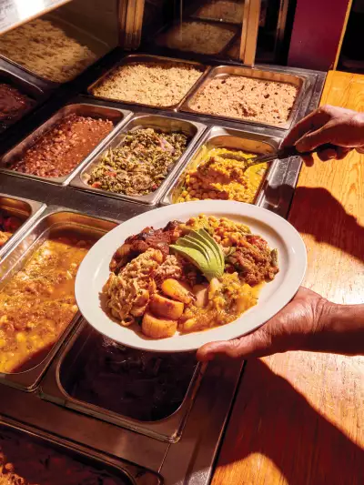 Vegan food in Toronto | Chef Pong scooping food onto a plate at V's Caribbean Restaurant