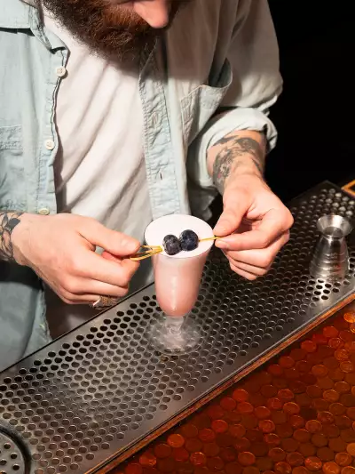 The best bars in Toronto | A bartender garnishing a creamy pink cocktail at Civil Liberties