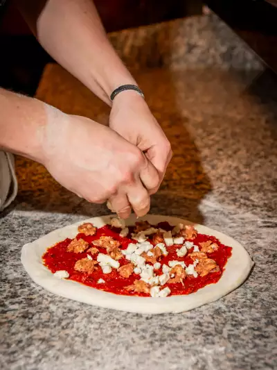 Toronto pizza | Adding the toppings to a pizza at Pizza e Pazzi