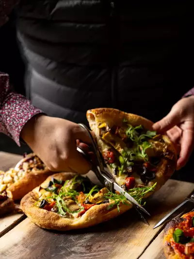 Best new Italian restaurants Toronto | Cutting a slice of pizza at Notte Ristorante