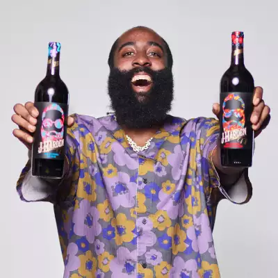 James Harden holding two bottles of red wine