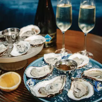 A tray of oysters and glasses on a table