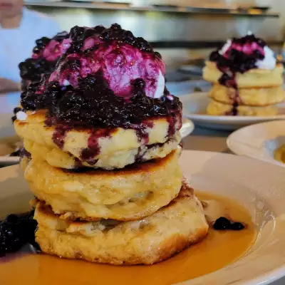 Best brunch Toronto | A stack of pancakes topped with cream and blueberries at Mildred's Temple Kitchen
