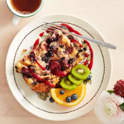 A beautiful slice of toast with fruit and sauce drizzled around the plate