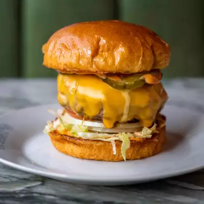 A juicy burger with melted cheese and pickles