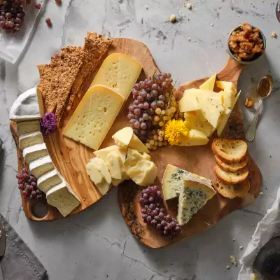 A charcuterie board with grapes and a selection of cheeses