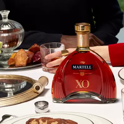 Martell Cordon XO cognac on the dinner table with a couple in the background