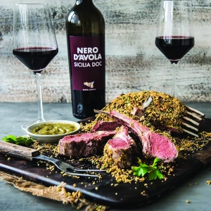 A large cut of crusted meat with a Nero D'Avola Sicilia DOC wine and glass A large cut of crusted meat with a Nero D'Avola Sicilia DOC wine and glass