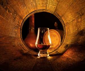 Canadian whisky | A glass of whisky inside a barrel