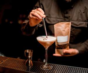 A bartender garnishing an espresso martini