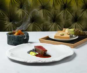 DaNico | Three dishes, including a meat plate, sit on a white tablecloth at DaNico in Little Italy