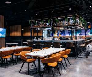 Tables in front of the bar at the Aspire | Air Canada Café at Billy Bishop Toronto City Airport