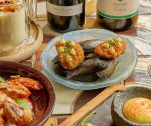 A spread of dishes and wine bottles at Madrina Bar y Tapas