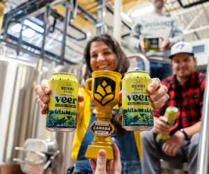 A woman holding two cans of Muskoka Brewery's Veer Lager with Lime
