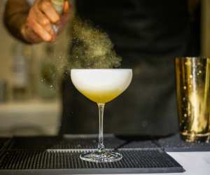 Toronto Cocktail Festival | A bartender spritzes a cocktail with mist