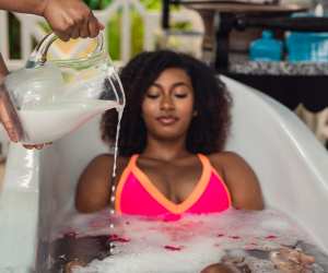Relax in St. Kitts | A jug of water is poured onto a woman in an outdoor bath tub in St. Kitts