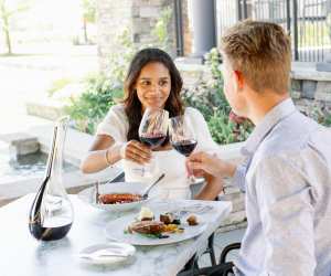 Trius Winery | A couple clink glasses on the patio at Trius Winery Restaurant