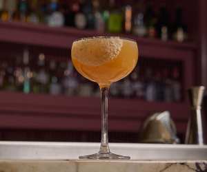 Deauville Club | A sour cocktail is picture on the bar at Deauville Club inside the Revery Hotel
