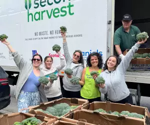 A group of Second Harvest volunteers holding up rescued broccoli