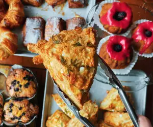Toronto cafés and coffee shops | A scone held up over other pastries at Coco's neighbourhood coffee shop