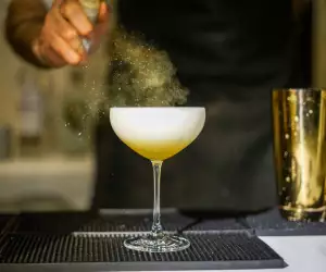 Toronto Cocktail Festival | A bartender spritzes a cocktail with mist
