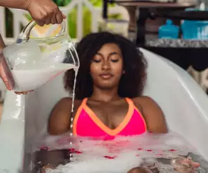 Relax in St. Kitts | A jug of water is poured onto a woman in an outdoor bath tub in St. Kitts