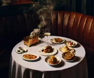 Punch Toronto | A shot of a table shot at Punch, featuring Beef Wellington, Scotch Egg and Mumbai Chat-Slaw