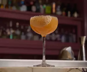Deauville Club | A sour cocktail is picture on the bar at Deauville Club inside the Revery Hotel
