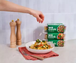 Sprinkling cheese onto a bowl of pasta from WeCook
