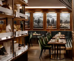 REIGN Toronto | Elegant dining room at Reign Toronto with green velvet seating, rich wood accents and warm lighting
