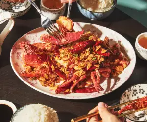 Toronto food and drink Instagram creators | A hand uses chopsticks to dish up food at Hong Shing Dining Room