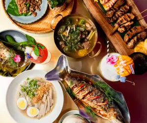 Isaan der Thai | An overhead shot of seabass, rice dishes and cocktails at the Spadina Avenue location of Isaan der Thai